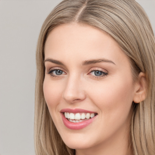 Joyful white young-adult female with long  brown hair and blue eyes