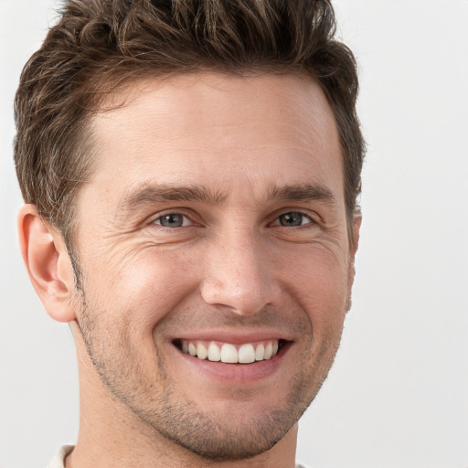 Joyful white adult male with short  brown hair and grey eyes