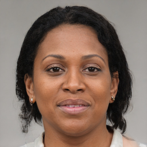 Joyful latino adult female with medium  brown hair and brown eyes