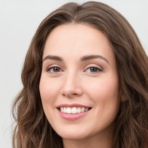 Joyful white young-adult female with long  brown hair and green eyes