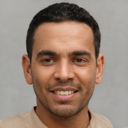 Joyful latino young-adult male with short  black hair and brown eyes