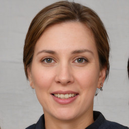 Joyful white young-adult female with medium  brown hair and grey eyes