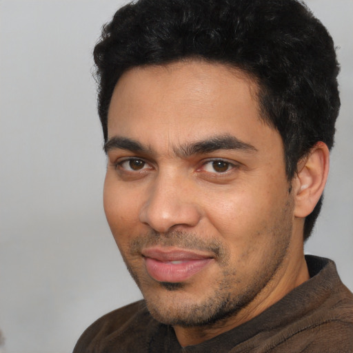 Joyful latino young-adult male with short  black hair and brown eyes