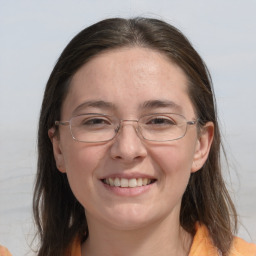 Joyful white adult female with long  brown hair and grey eyes