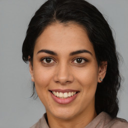 Joyful latino young-adult female with medium  brown hair and brown eyes