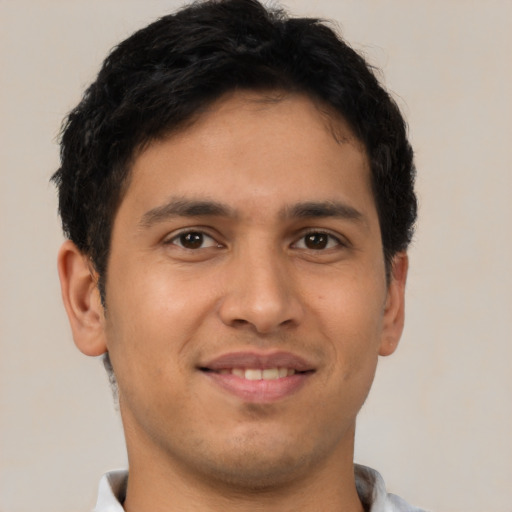 Joyful latino young-adult male with short  brown hair and brown eyes