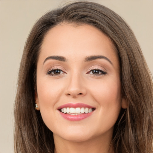 Joyful white young-adult female with long  brown hair and brown eyes