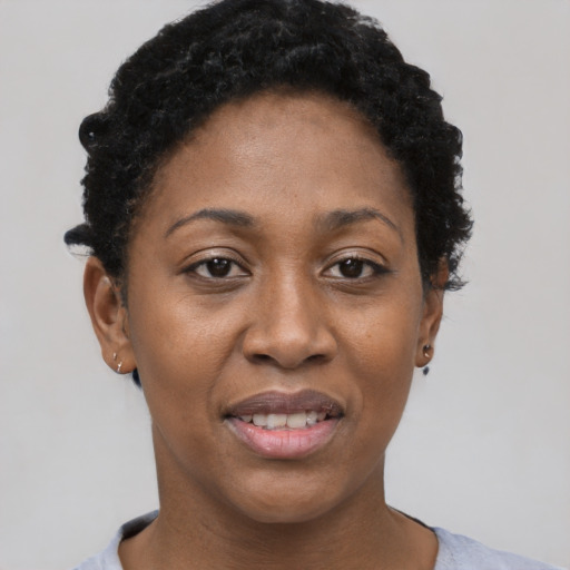 Joyful black adult female with short  black hair and brown eyes