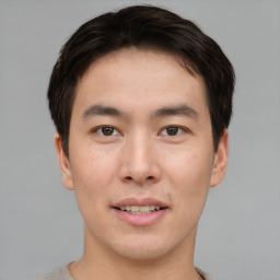 Joyful asian young-adult male with short  brown hair and brown eyes