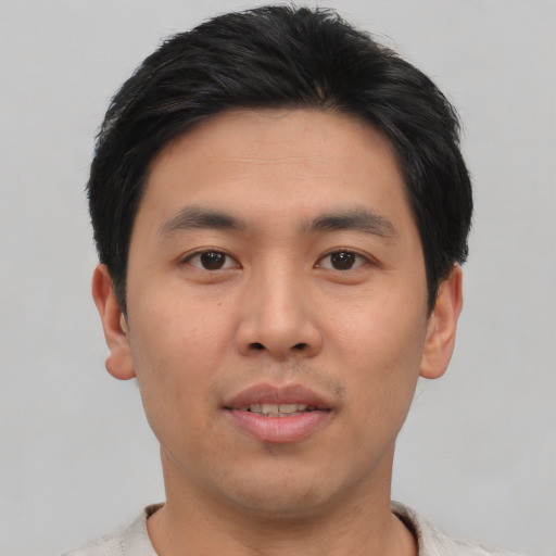 Joyful asian young-adult male with short  brown hair and brown eyes