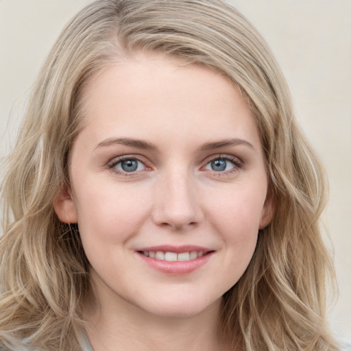 Joyful white young-adult female with long  brown hair and blue eyes