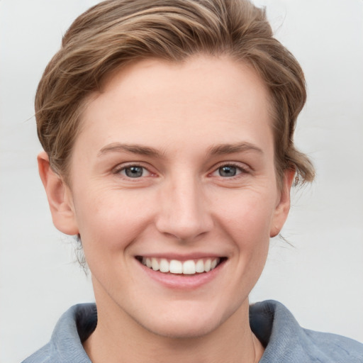 Joyful white young-adult female with short  brown hair and grey eyes