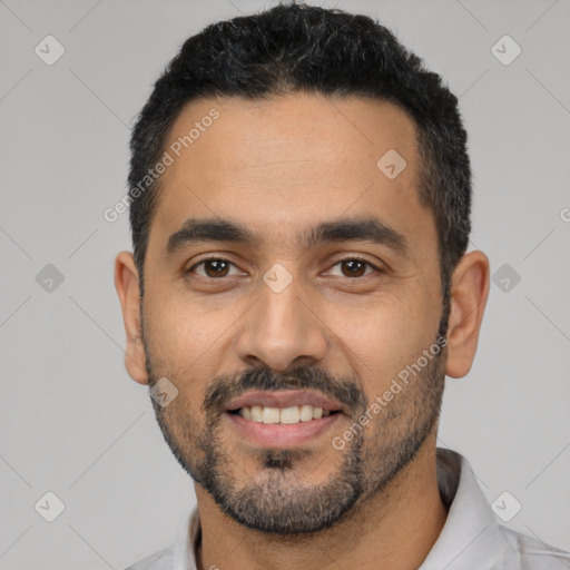 Joyful latino young-adult male with short  black hair and brown eyes