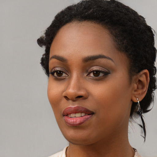 Joyful black young-adult female with short  black hair and brown eyes