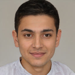 Joyful latino young-adult male with short  brown hair and brown eyes