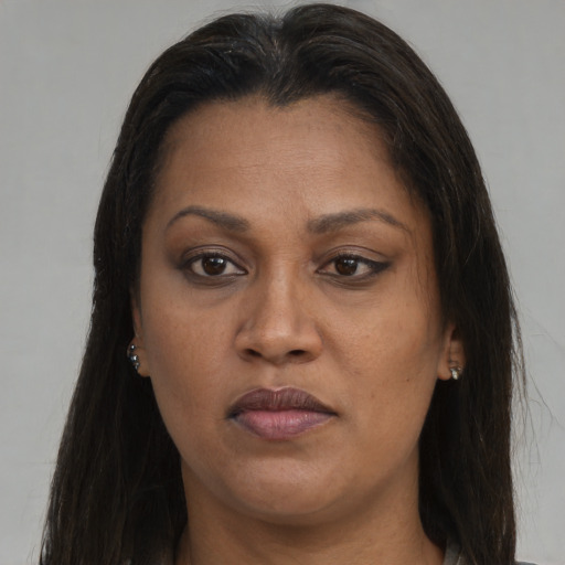 Joyful black adult female with long  brown hair and brown eyes