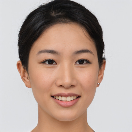 Joyful asian young-adult female with short  brown hair and brown eyes