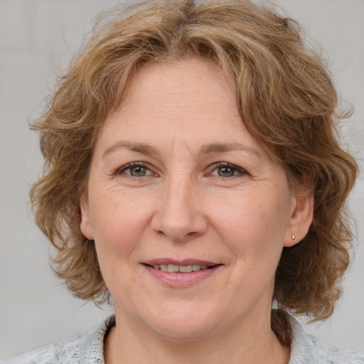 Joyful white adult female with medium  brown hair and blue eyes