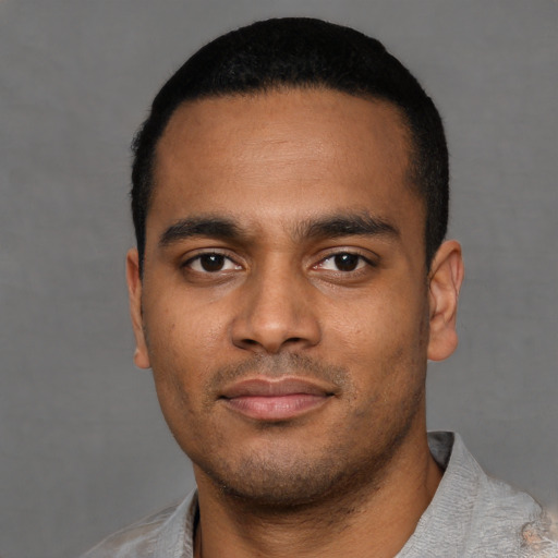 Joyful latino young-adult male with short  black hair and brown eyes