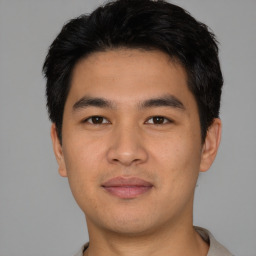 Joyful asian young-adult male with short  black hair and brown eyes