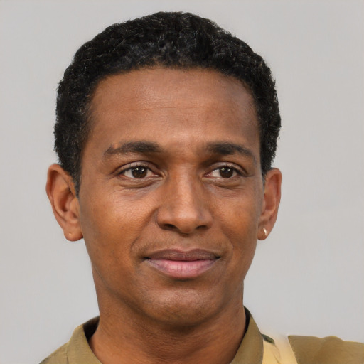 Joyful black adult male with short  black hair and brown eyes