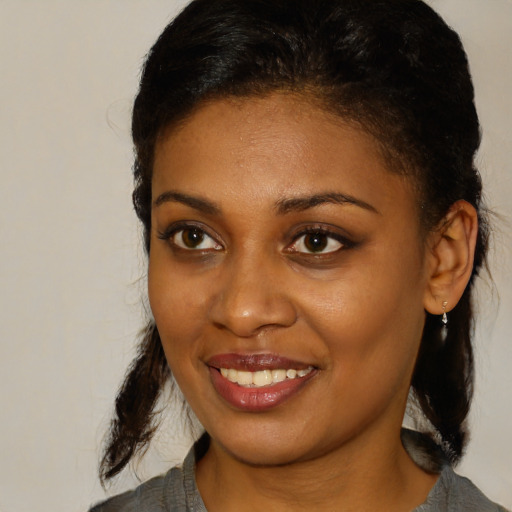 Joyful black young-adult female with medium  black hair and brown eyes