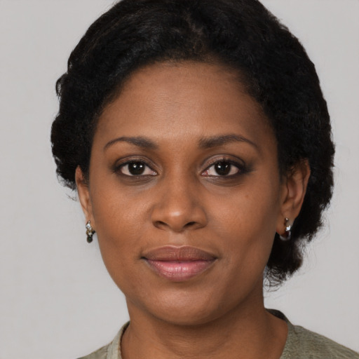 Joyful black adult female with short  brown hair and brown eyes