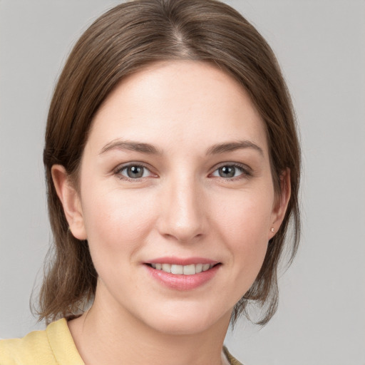 Joyful white young-adult female with medium  brown hair and grey eyes