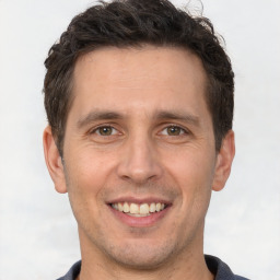 Joyful white adult male with short  brown hair and brown eyes