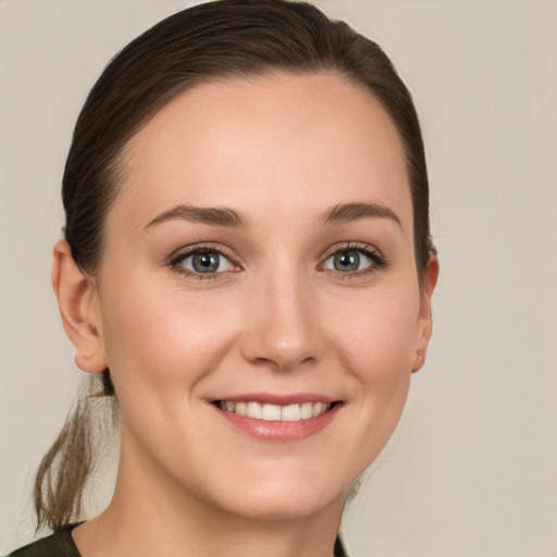 Joyful white young-adult female with medium  brown hair and green eyes