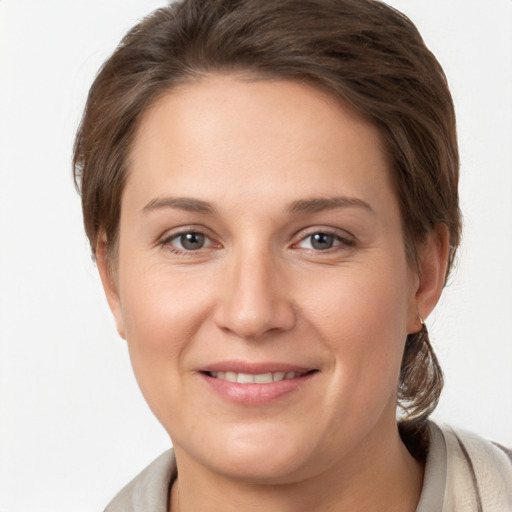 Joyful white young-adult female with medium  brown hair and grey eyes