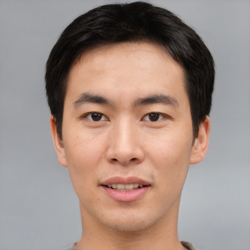 Joyful asian young-adult male with short  brown hair and brown eyes