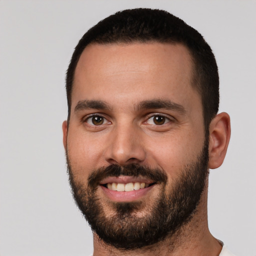 Joyful white young-adult male with short  black hair and brown eyes