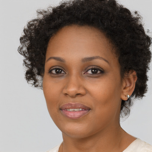 Joyful black young-adult female with short  brown hair and brown eyes