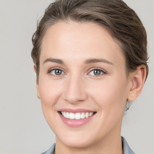 Joyful white young-adult female with short  brown hair and grey eyes