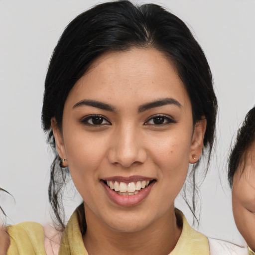 Joyful white young-adult female with medium  black hair and brown eyes