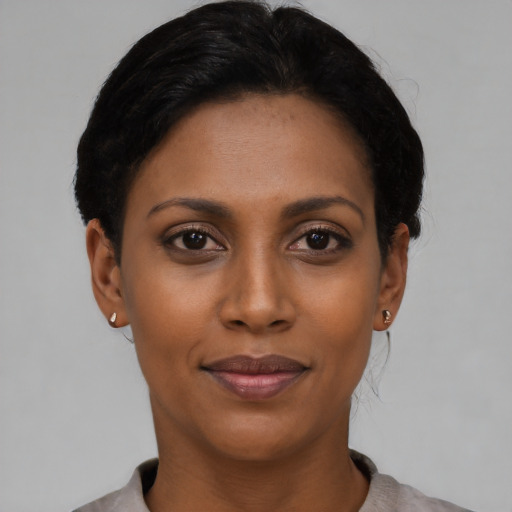 Joyful latino young-adult female with short  black hair and brown eyes