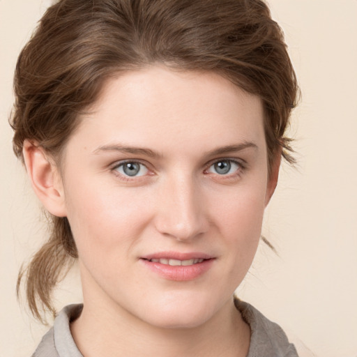 Joyful white young-adult female with medium  brown hair and grey eyes