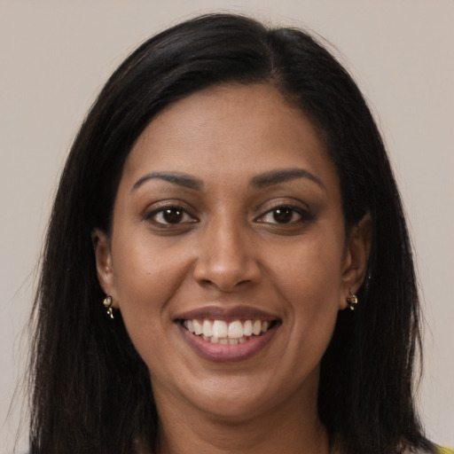 Joyful black young-adult female with long  brown hair and brown eyes