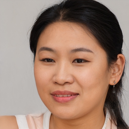 Joyful asian young-adult female with medium  brown hair and brown eyes