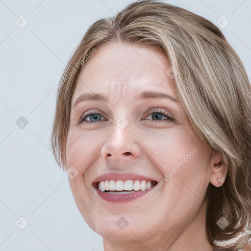 Joyful white young-adult female with medium  brown hair and blue eyes