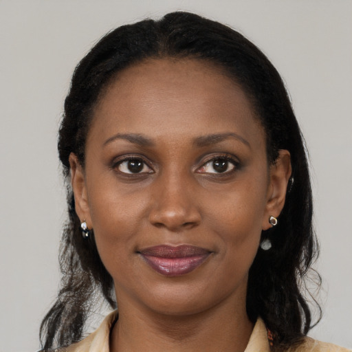 Joyful black young-adult female with long  brown hair and brown eyes