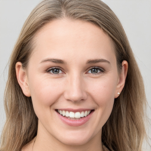 Joyful white young-adult female with long  brown hair and grey eyes