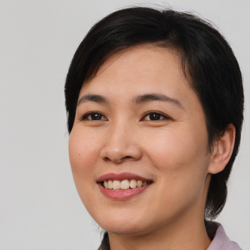 Joyful asian young-adult female with medium  black hair and brown eyes