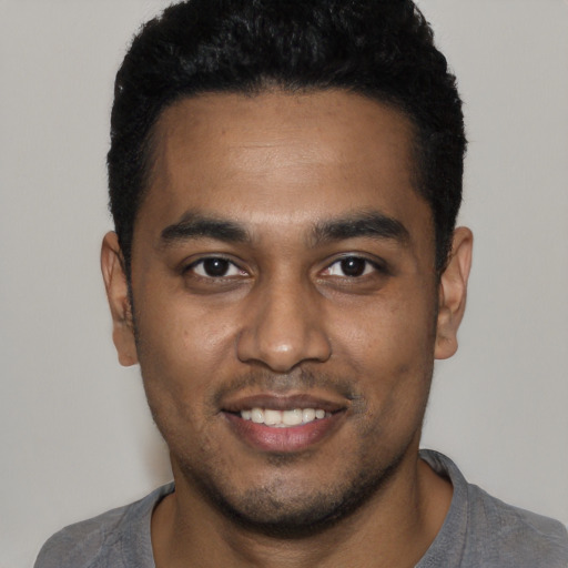 Joyful black young-adult male with short  black hair and brown eyes