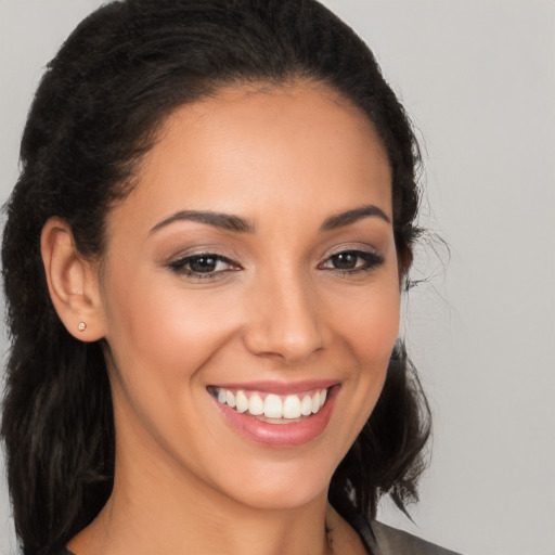 Joyful latino young-adult female with long  brown hair and brown eyes