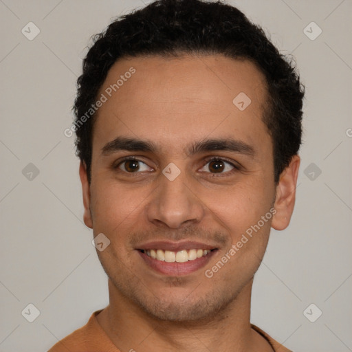 Joyful latino young-adult male with short  black hair and brown eyes