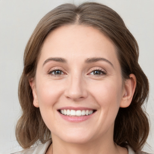 Joyful white young-adult female with medium  brown hair and grey eyes