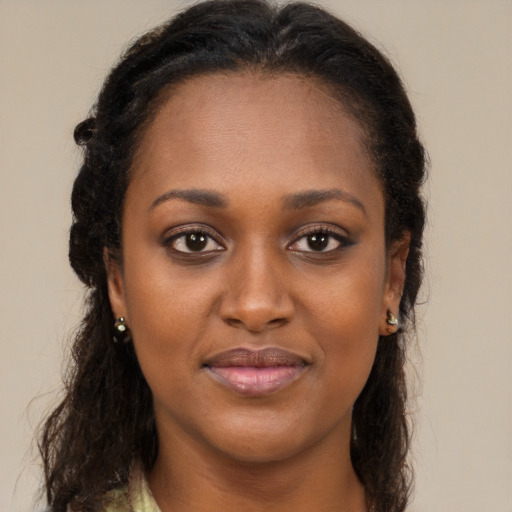 Joyful black young-adult female with long  brown hair and brown eyes