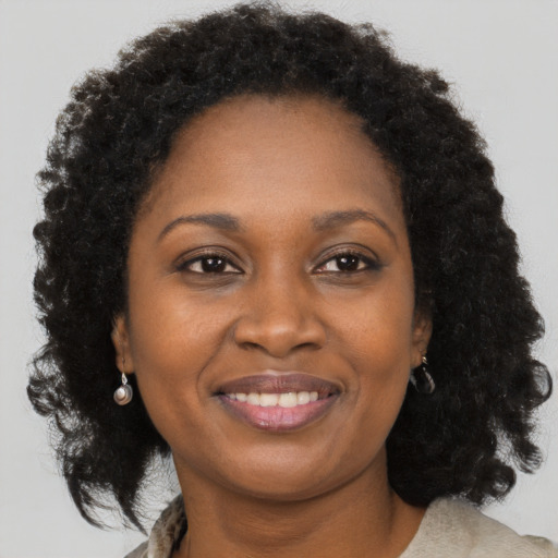 Joyful black young-adult female with long  brown hair and brown eyes